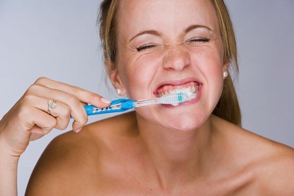 0 Woman brushing her teeth smiling close up