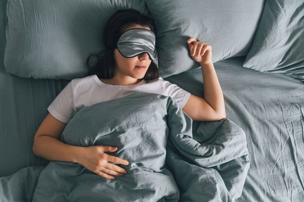 0 woman sleep in eye patch in grey bed copy space