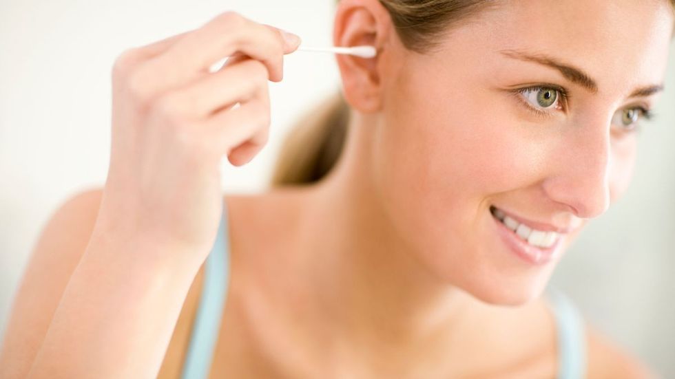 0 Young woman cleaning ear smiling