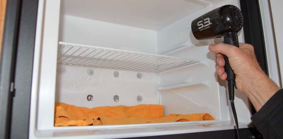 04 681 Defrosting RV refrigerator hair dryer on freezer with towels