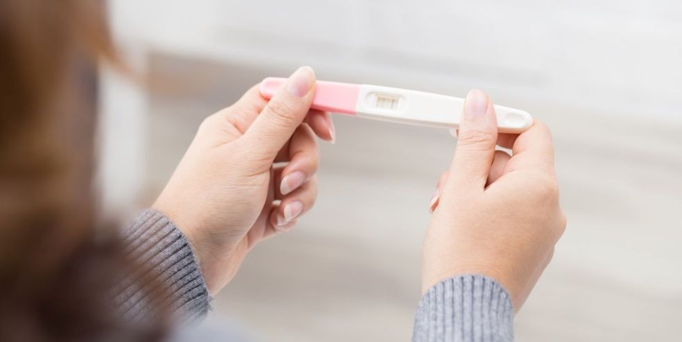 1214 Woman holding a pregnancy test