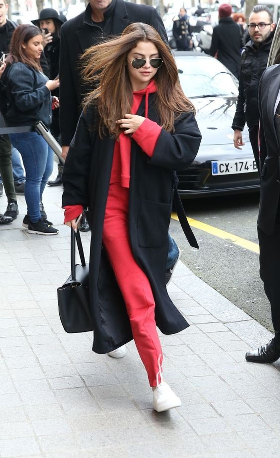 16 a red tracksuit white sneakers a black coat and a bag by Selena Gomez