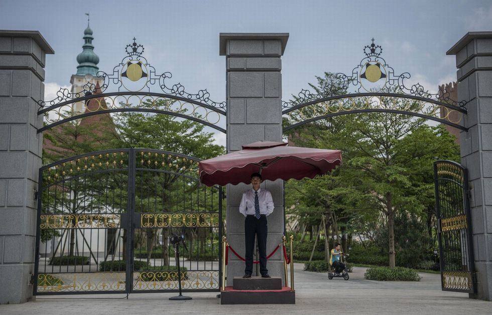 1A Huawei security guard stands outside a gate.