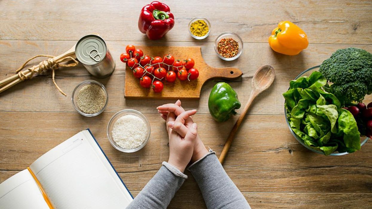 2018/07/woman-leaning-on-table-with-various-ingredients-and-a-diet-planning-book.jpg