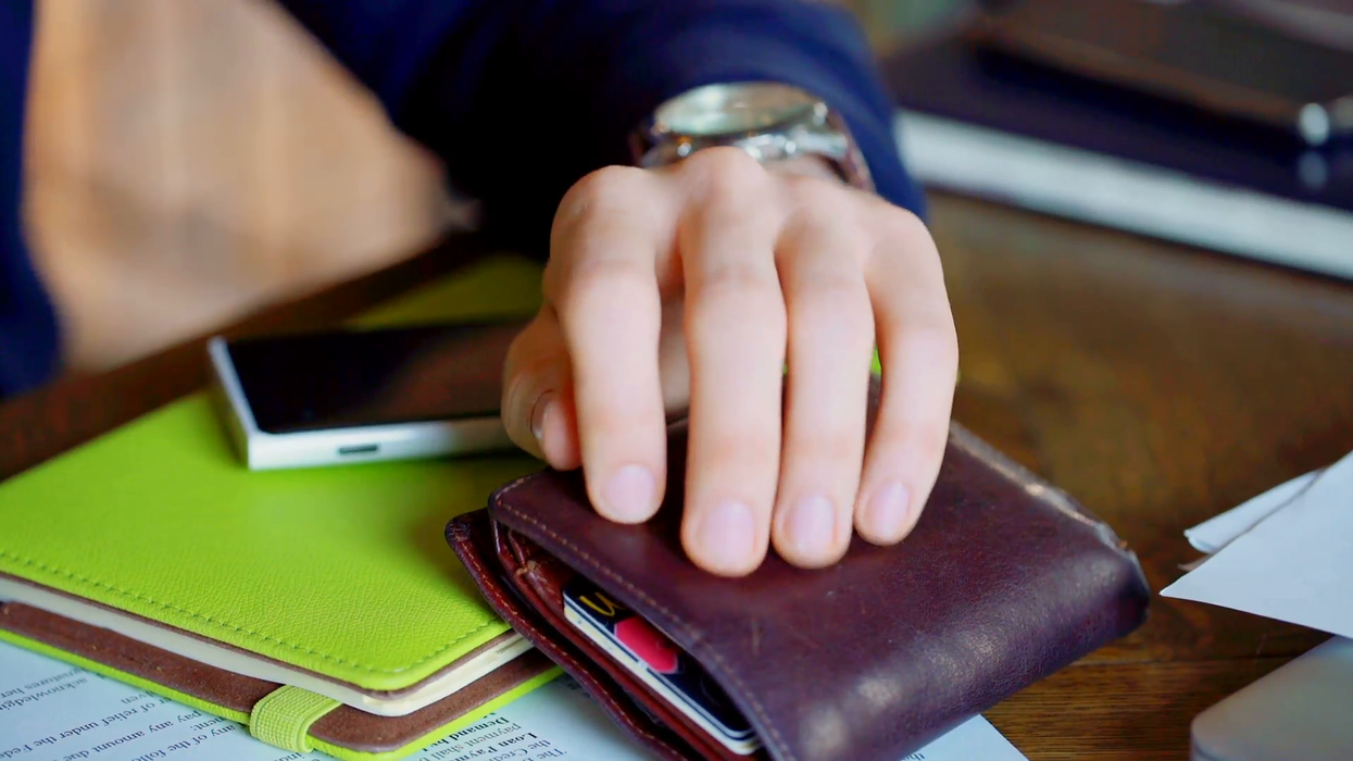 2018/10/businessmans-hand-holding-wallet-which-lies-on-the-table_vuyjbnm3e__F0000.png