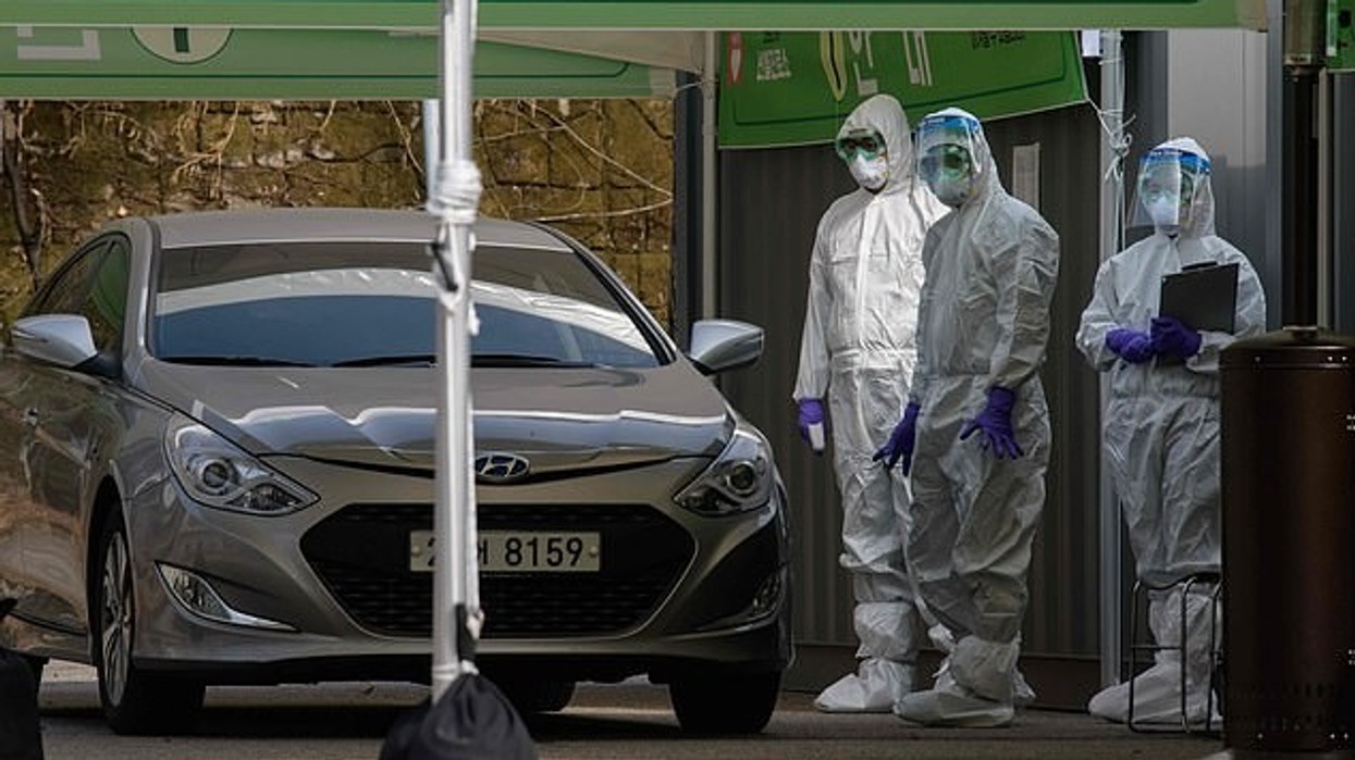2020/03/25656134-8085957-Three_health_workers_in_protective_suits_wait_to_check_a_motoris-a-68_1583586475697.jpg