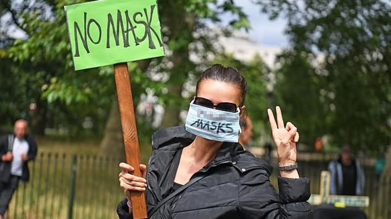 2020/09/30946012-0-A_woman_holds_a_sign_and_wears_a_mask_as_she_protests_in_Hyde_Pa-a-2_1598861150085.jpg