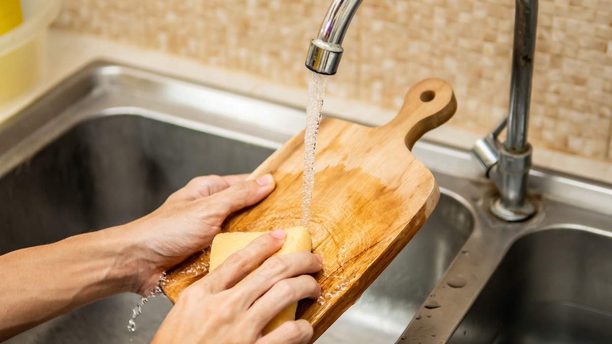 2020/10/cleaning-wood-cutting-board-in-kitchen-sink-royalty-free-image-1583340534-scaled.jpg