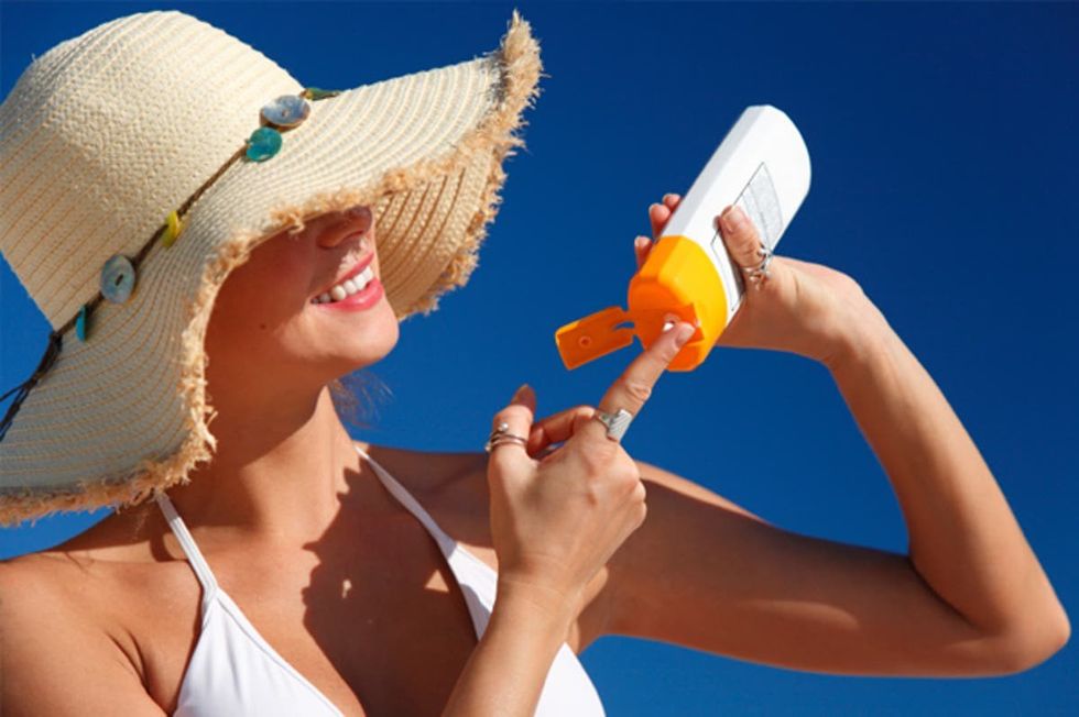 2021/06/woman-applying-sunscreen-at-beach.jpg
