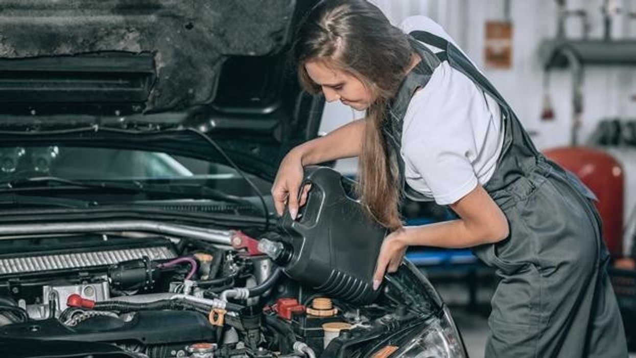 2022/01/beautiful-girl-black-jumpsuit-white-t-shirt-is-smiling-checking-oil-level-black-car-garage_161422-1324.jpg