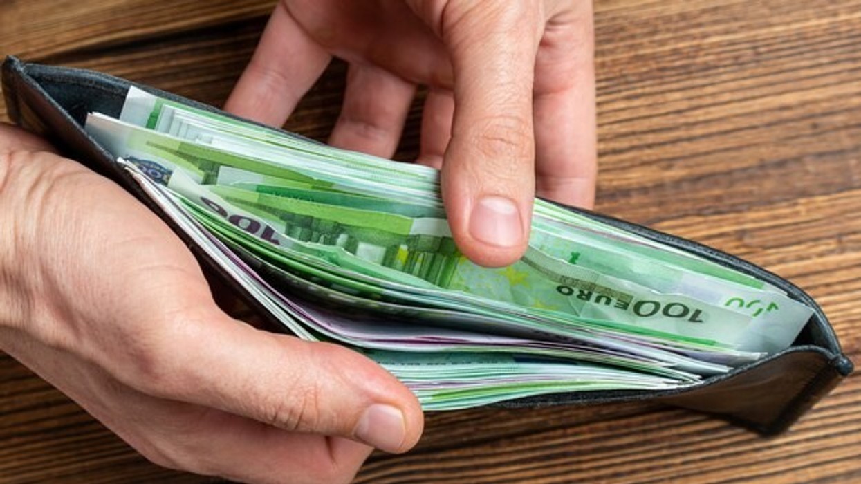 2022/02/hands-holding-wallet-full-money-banknotes_157402-2220.jpg