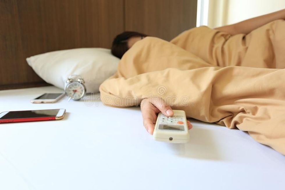 2022/07/young-woman-hand-hold-remote-air-conditioner-sleeping-bedroom-home-138360265.jpg