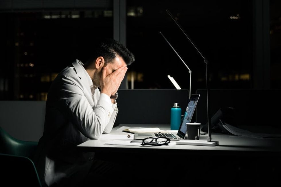 2022/11/male-employee-tired-at-desk-mental-fatigue.jpg