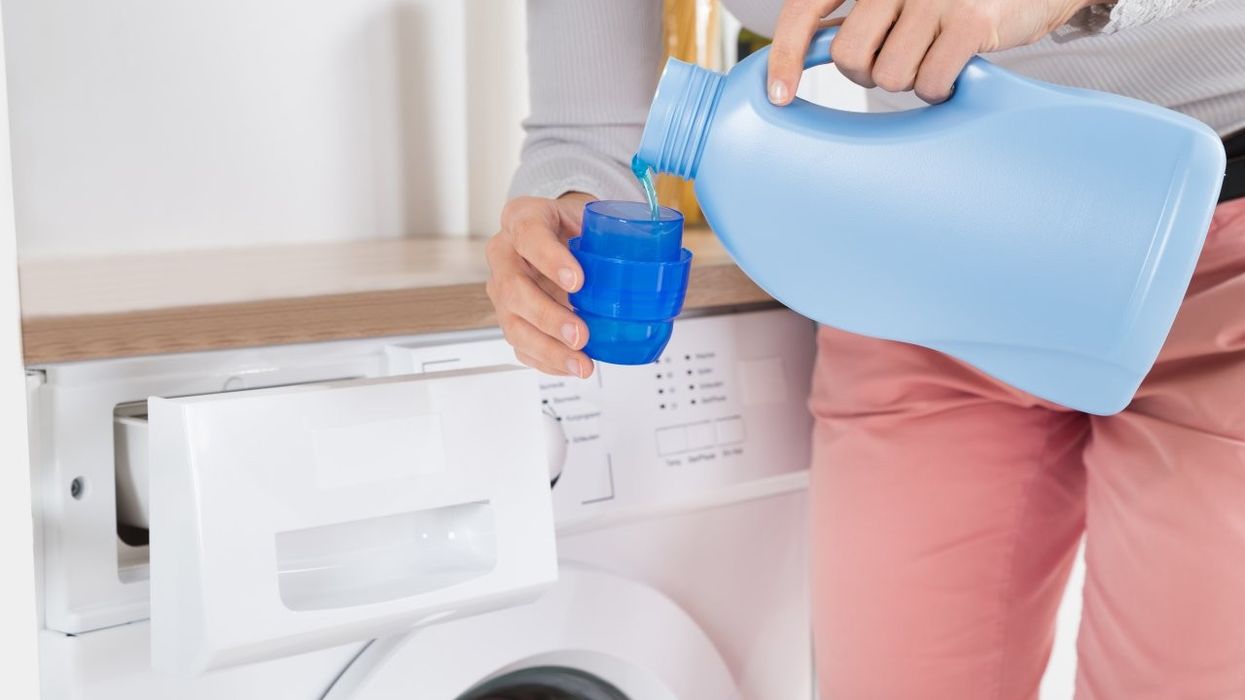 2024/07/woman-in-pink-trousers-pouring-fabric-conditioner-into-a-bottle-cap.jpg
