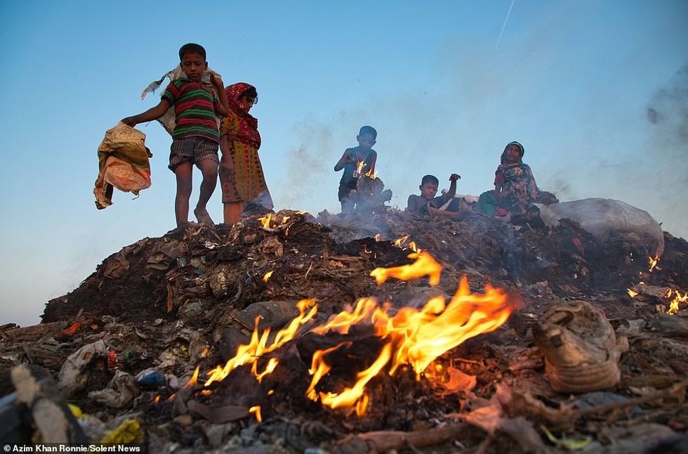 21647714 7741389 Children bravely sift through burning piles of rubbish to find i a 61 1575119188114 1