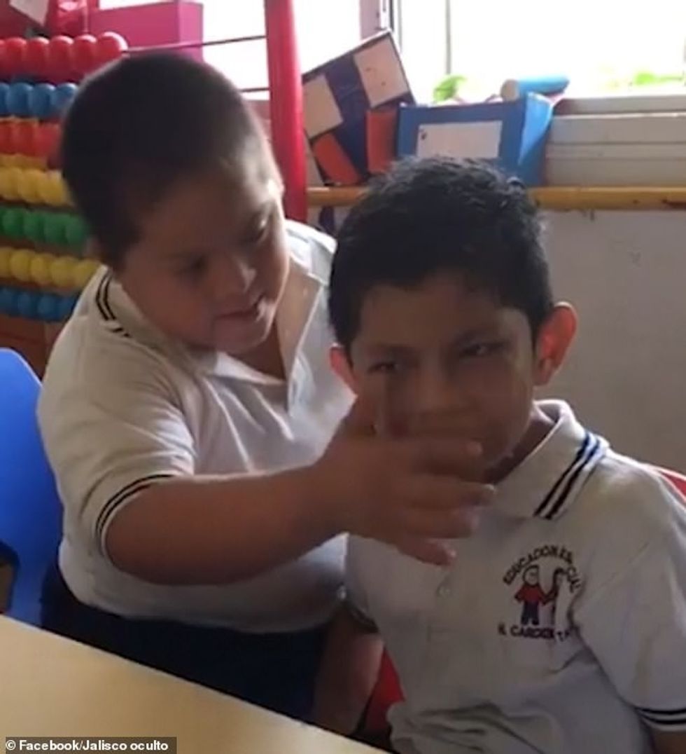 21875458 7761043 The little boy with autism who is sitting at his desk appears to a 34 1575575958965