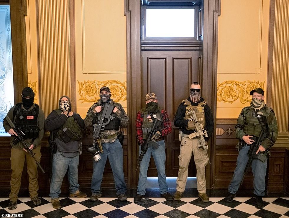27860720 8275171 A militia group with no political affiliation stands in front of a 115 1588283688687