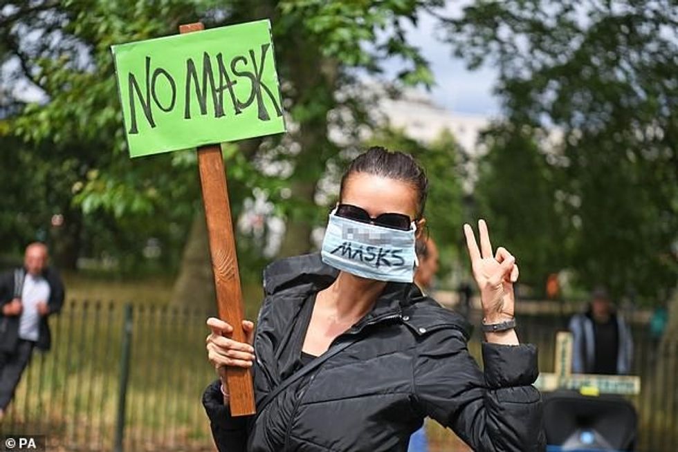 30946012 0 A woman holds a sign and wears a mask as she protests in Hyde Pa a 2 1598861150085