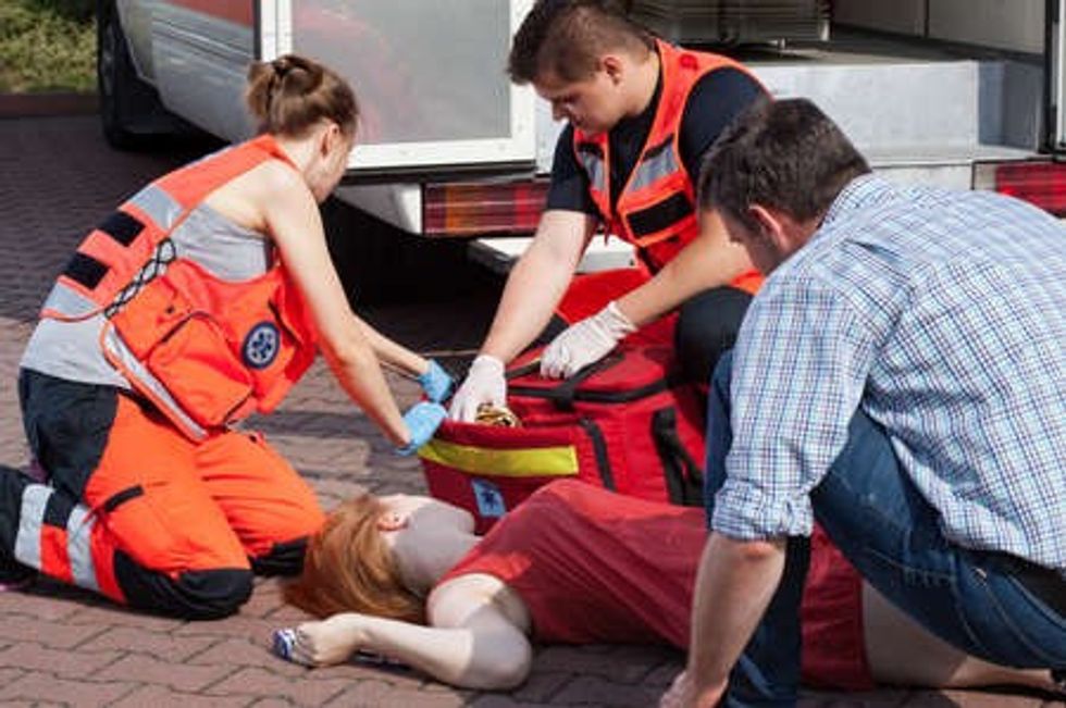 30973062 emergency service helping unconscious woman on the street