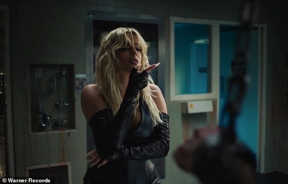 40072456 9329011 Leather queen She dons a plunging black leather halter catsuit w a 3 1614930970219