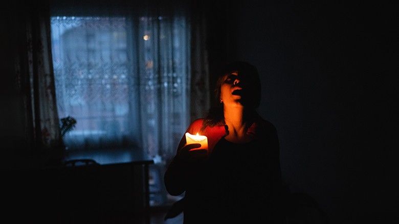 2024/02/Woman-with-candle-at-home-because-of-power-cut.jpg