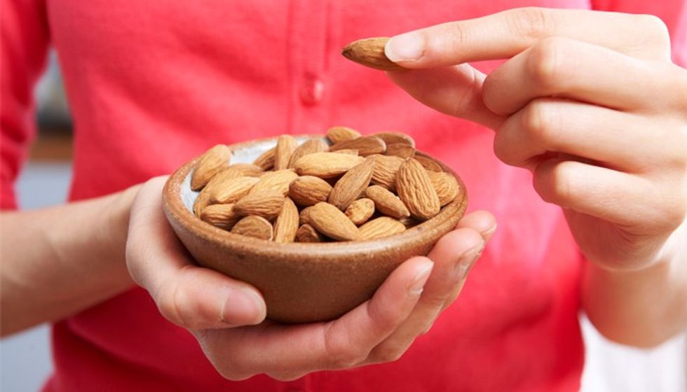 49871539 woman eating healthy snack of almonds