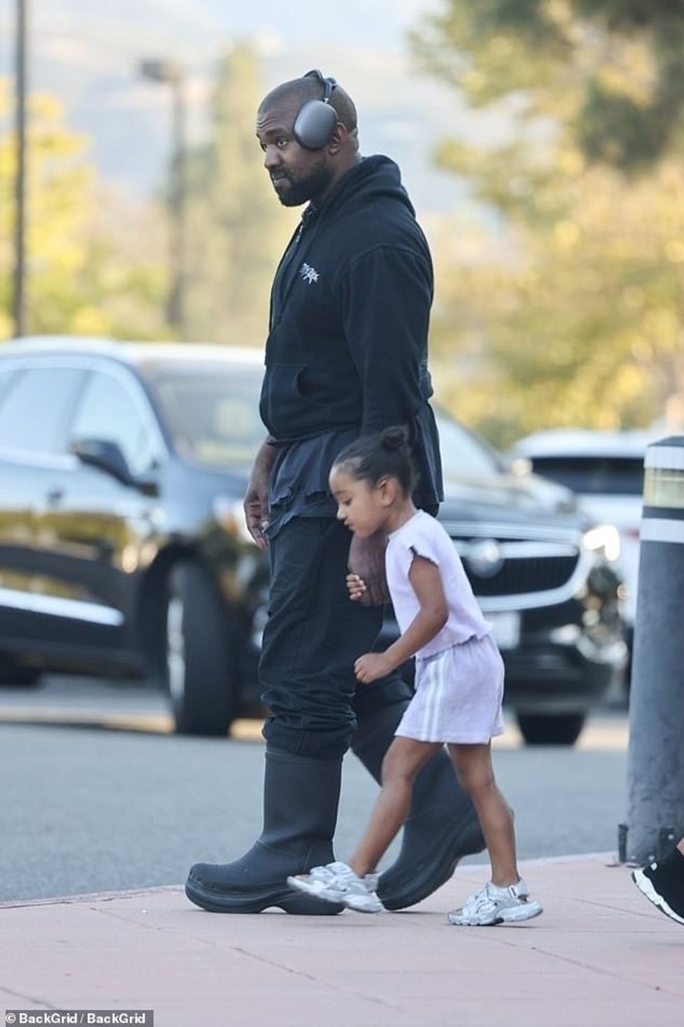 60866053 11063995 Hand holding A pair of big gray headphones sat atop his head tho a 2 1659159869517