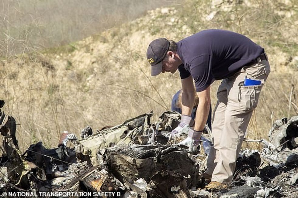 61420739 11143583 Crash seen investigators are seen examining the wreckage of the a 1 1661393439130