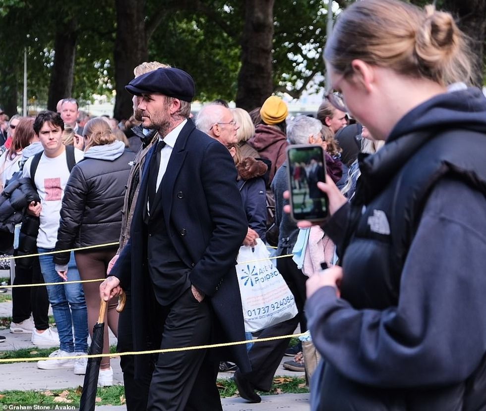 62480659 11219511 Beckham carried an umbrella and seemed unfazed as fans took phot a 58 1663339552666