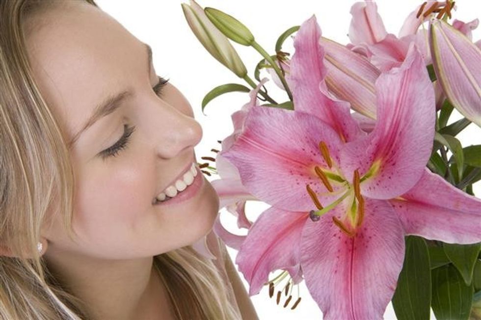 640 157579842 woman holding pink lily flowers