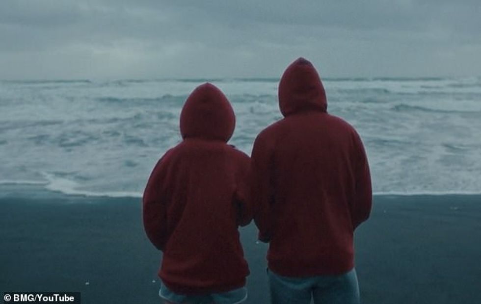 72704353 12250065 Side by side She is joined by a hooded companion as they gaze ou a 60 1688113493192