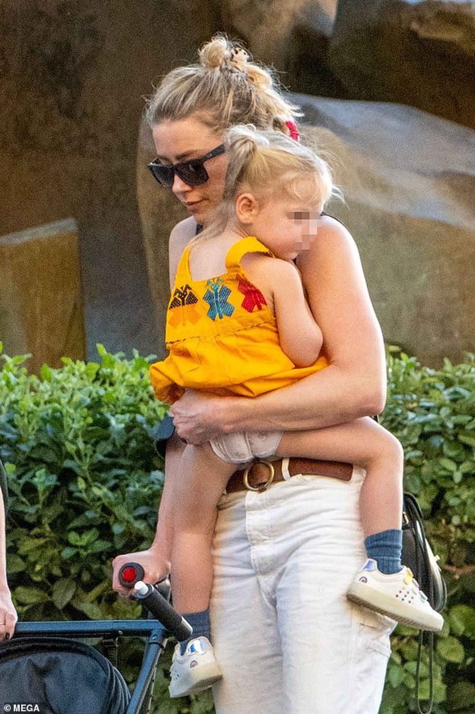 76126363 12590505 Carrying her baby Her toddler daughter was dressed in an orange a 93 1696368685449