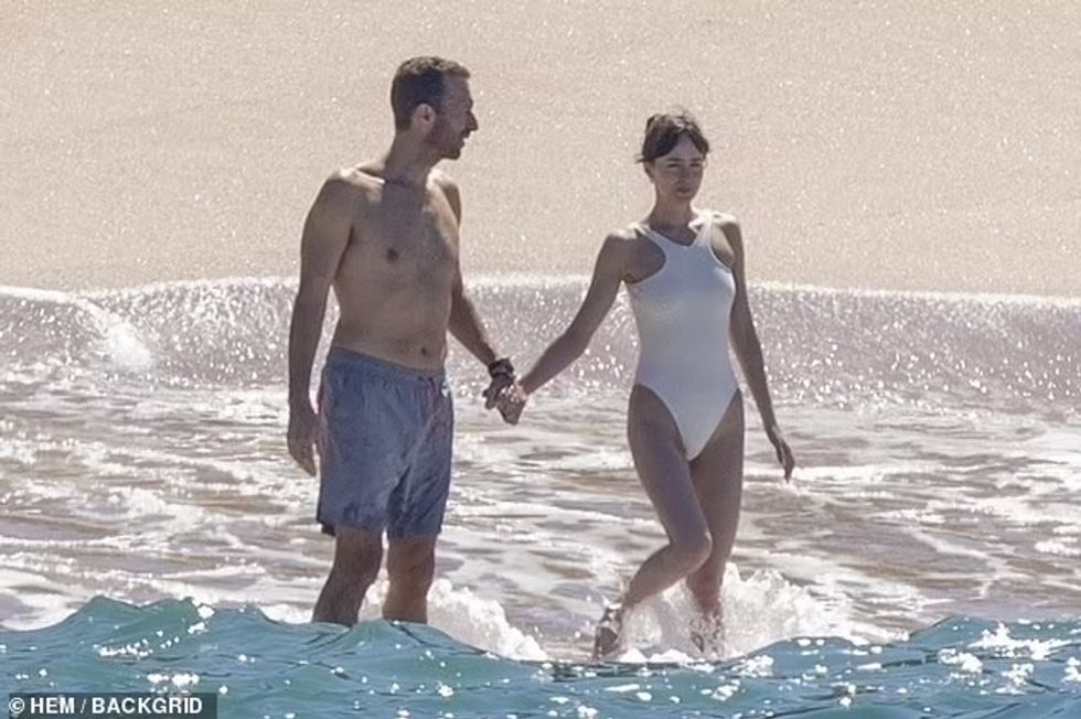 81498987 13105721 The couple held hands as they splashed around the water before r a 30 1708461412774