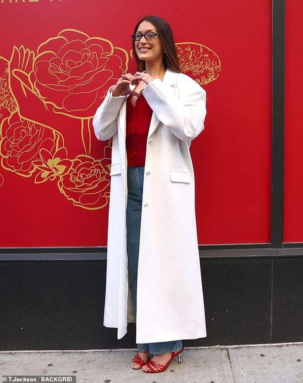 93157113 14193699 Hadid showed off her curves wearing a low cut red button up swea a 12 1734221867376