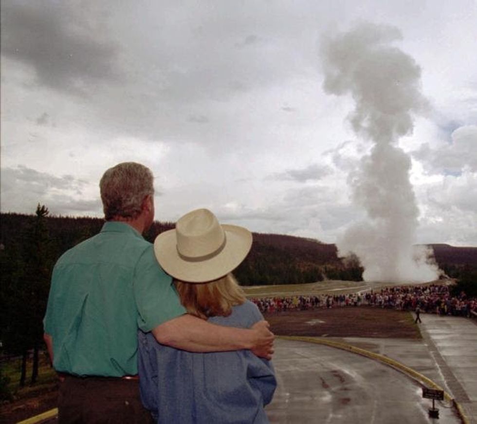 95 President Clinton puts an arm around his wife, Hillary, while watching Old Faithful erupt at Yellowstone National Park, Wyo., Friday, Aug. 25, 1995. The first family visited several Yellowstone sites while on vacation. (AP Photo/Doug Mills)