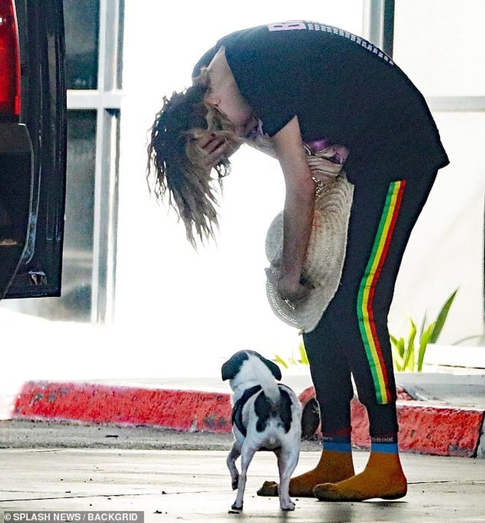 97227745 14604773 Another moment showed the model bending over next to her dog Alf a 2 1744570417791