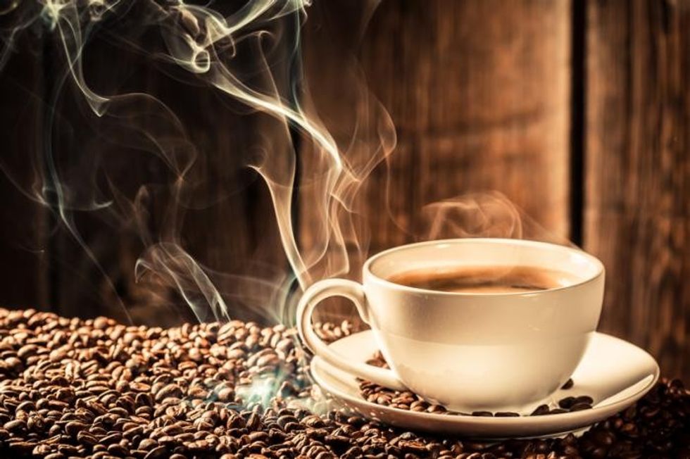 a cup of hot coffee with coffee beans