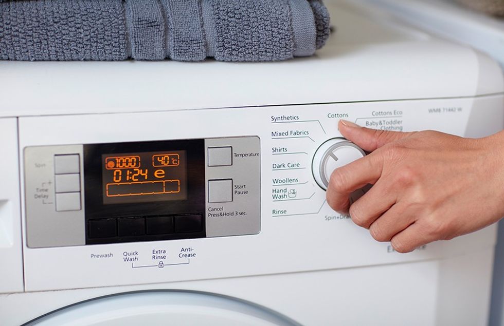A Hand Using a Washing Machine