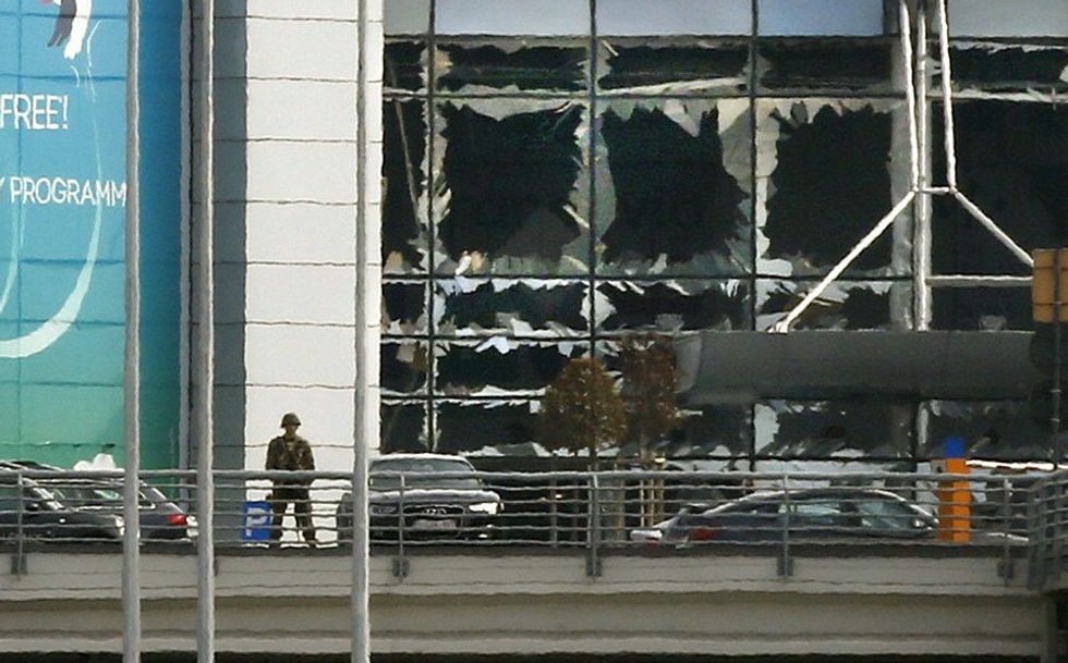 A soldier stands near broken windows after explosions at Zaventem airport near Brussels, Belgium, March 22, 2016. REUTERS/Francois Lenoir - RTSBM7B