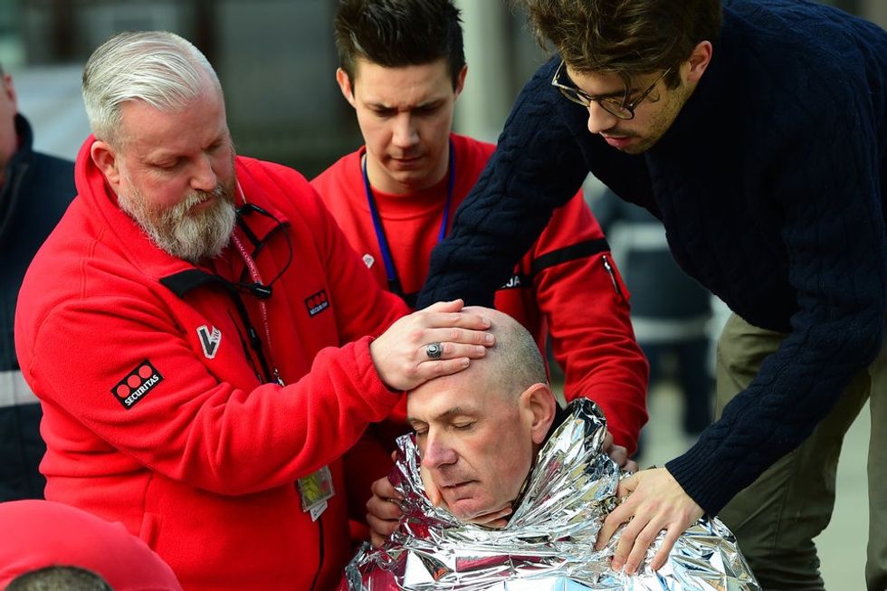 A victim receives first aid by rescuers, on March 22, 2016 near Maalbeek metro station in Brussels, after a blast at this station near the EU institutions caused deaths and injuries. AFP PHOTO / EMMANUEL DUNAND / AFP / EMMANUEL DUNAND (Photo credit should read EMMANUEL DUNAND/AFP/Getty Images)