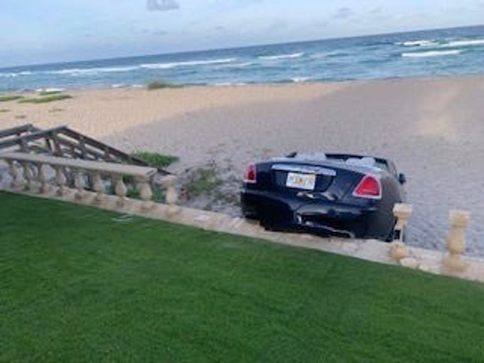 A woman drove her Rolls-Royce sedan through a backyard on Canterbury Lane in Palm Beach, then through a seawall, before coming to rest on the beach, Palm Beach Police say. (Palm Beach Police)