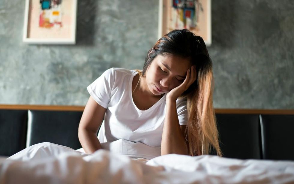 a woman lying in bed and feeling unwell because of malaise