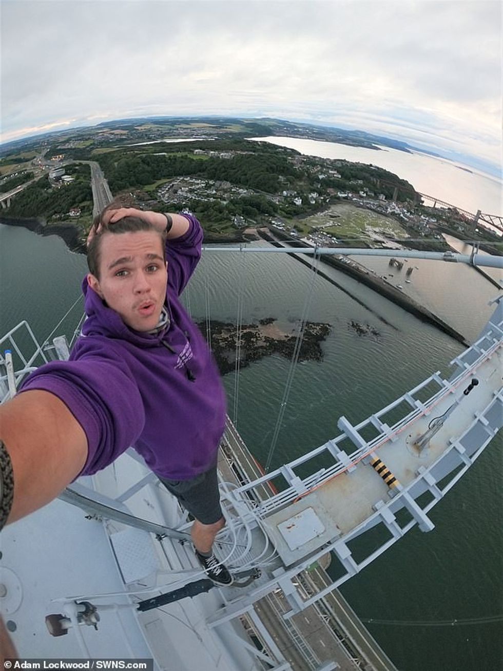 Adam Lockwood, 19, posed for a selfie at the top of Forth Road Bridge which towers 500ft above the River Forth in central Scotland