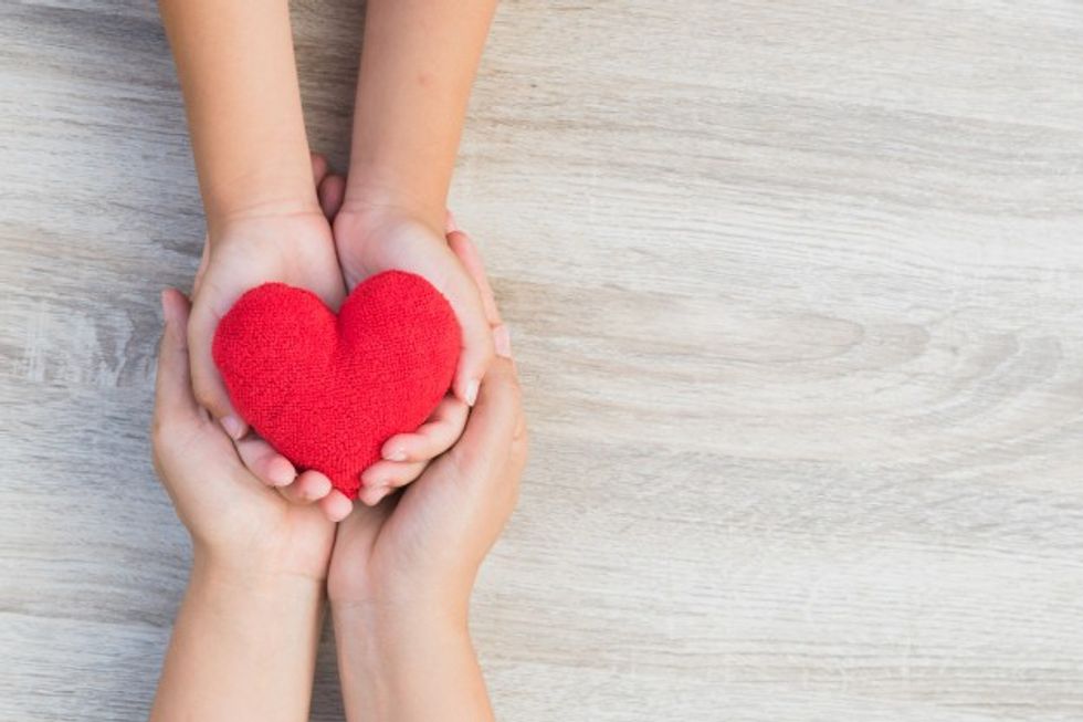 adult child hands holding handmade red heart wooden background 53476 1084