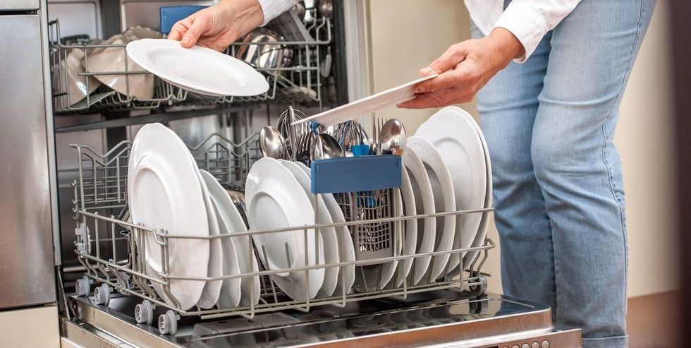 adult woman unloading dishwasher in the kitchen royalty free image 1594133280