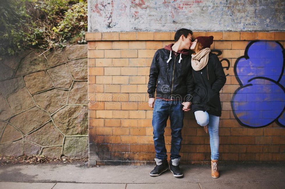 affectionate teenage couple kissing street 37737014