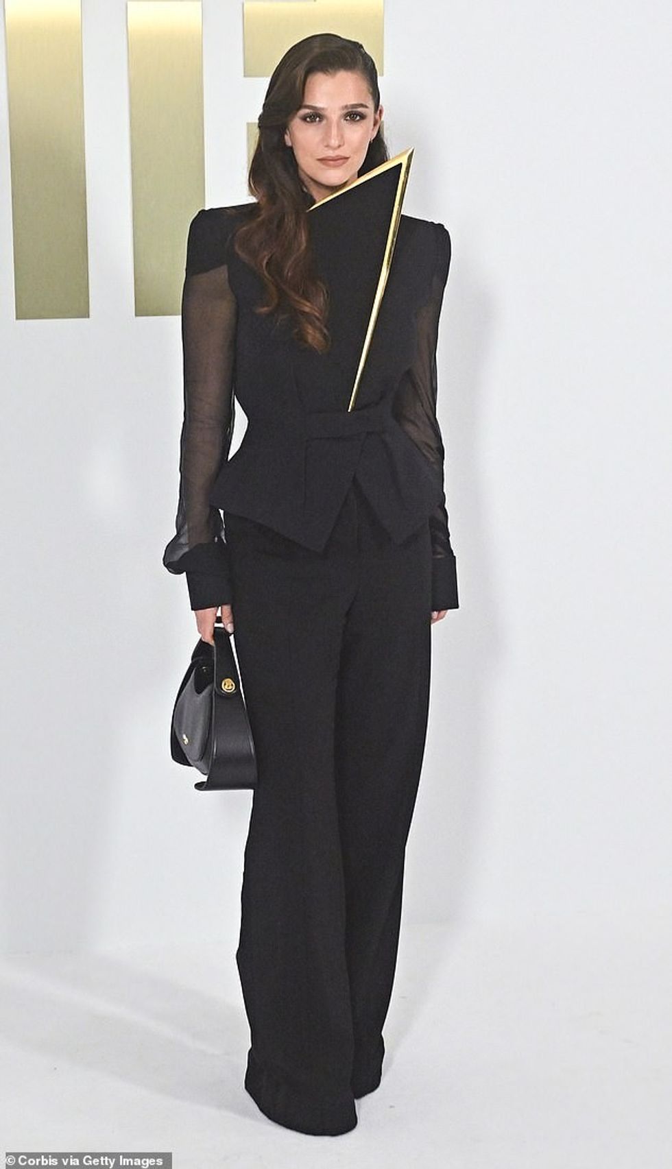 Ajo e kombinoi xhaketën mbresëlënëse me pantallona të zeza me këmbë të gjera dhe taka me platformë