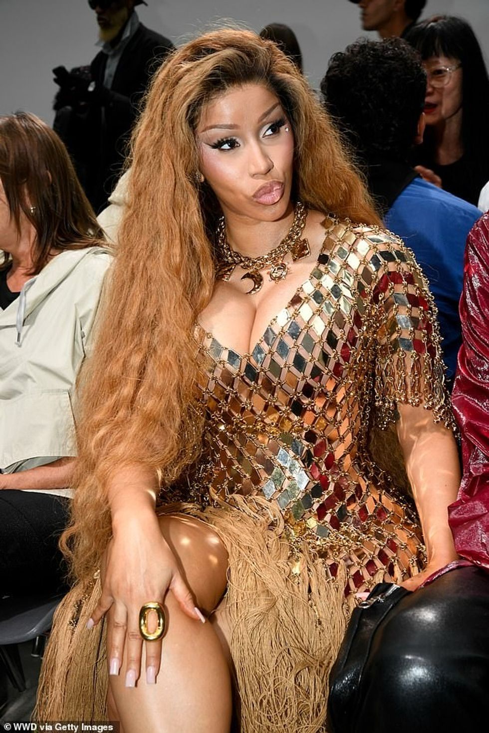 Ajo e plotësoi look-un që kthente kokën me një gjerdan të trashë ari dhe i shtoi gjatësisë me taka metalike.