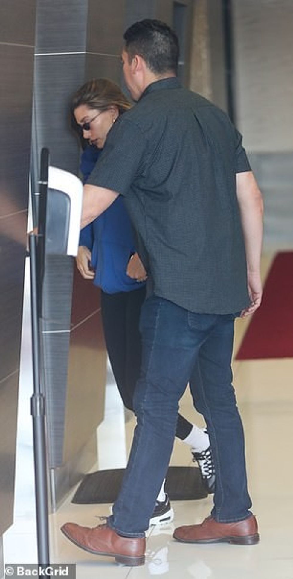 Ajo i veshi flokët e saj të errët në një stil natyralisht të drejtë, duke i shtyrë nga fytyra e saj ndërsa po shkonte për në spa.