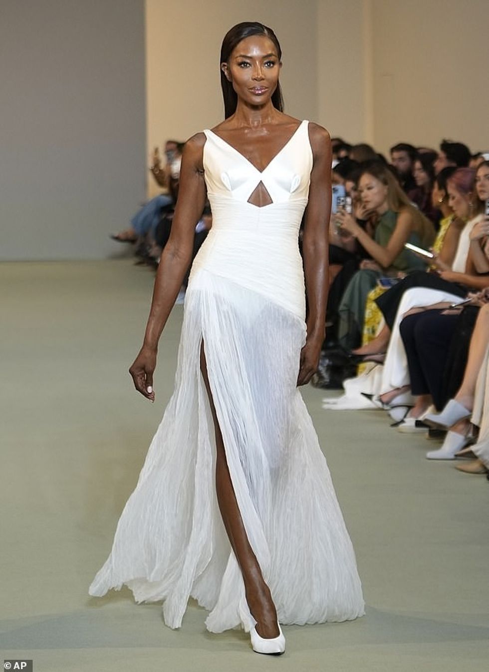 Ajo vendosi një ekran këmbëgjatë përmes një ndarje të guximshme të kofshës dhe shtoi centimetra në kornizën e saj në një palë stileto të larta